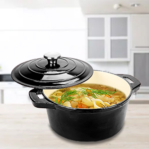 Black cast iron Dutch oven with lid, filled with a light colored stew, sits on a light colored kitchen counter.